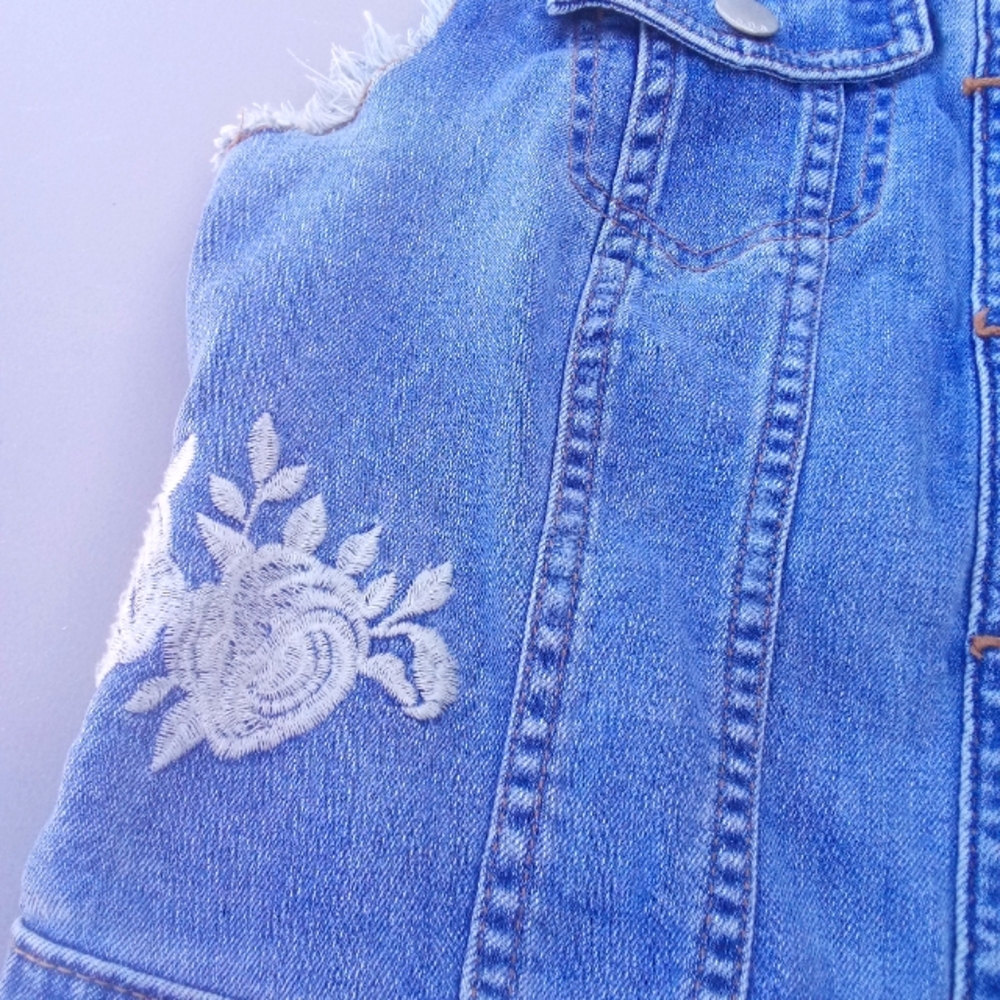 Sleeveless denim jacket embossed with roses